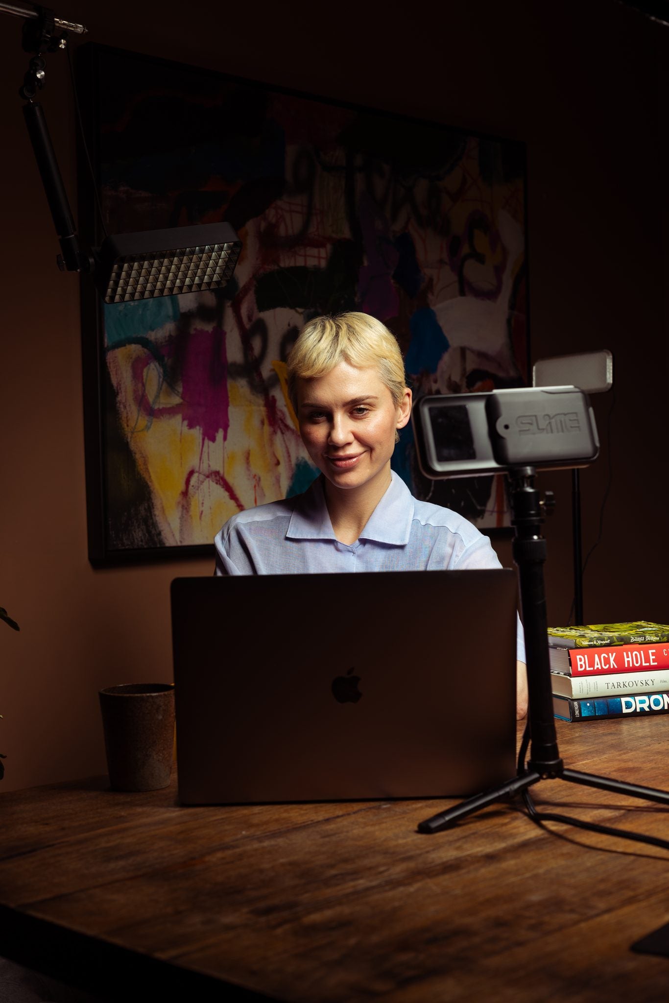A professional smiling at her desk, lit by SLITE.pop and a panel