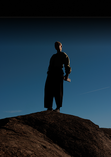 Lynda standing on a rock under a blue sky